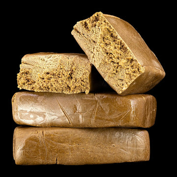 Stack of brown cannabis hash bars on a black background