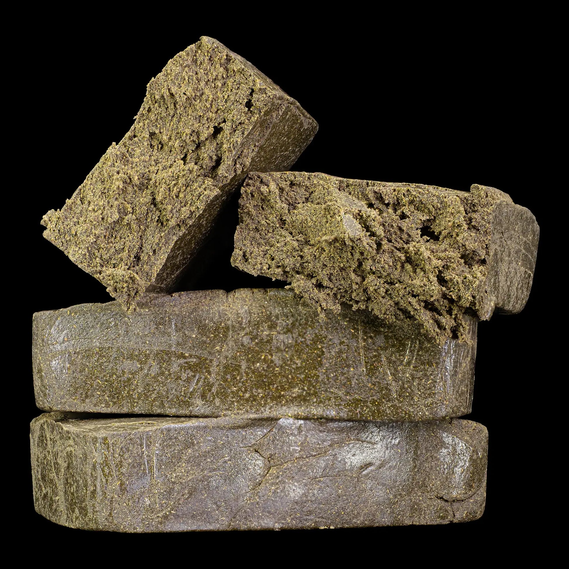Stack of hash bricks with a dark background manali cream thca